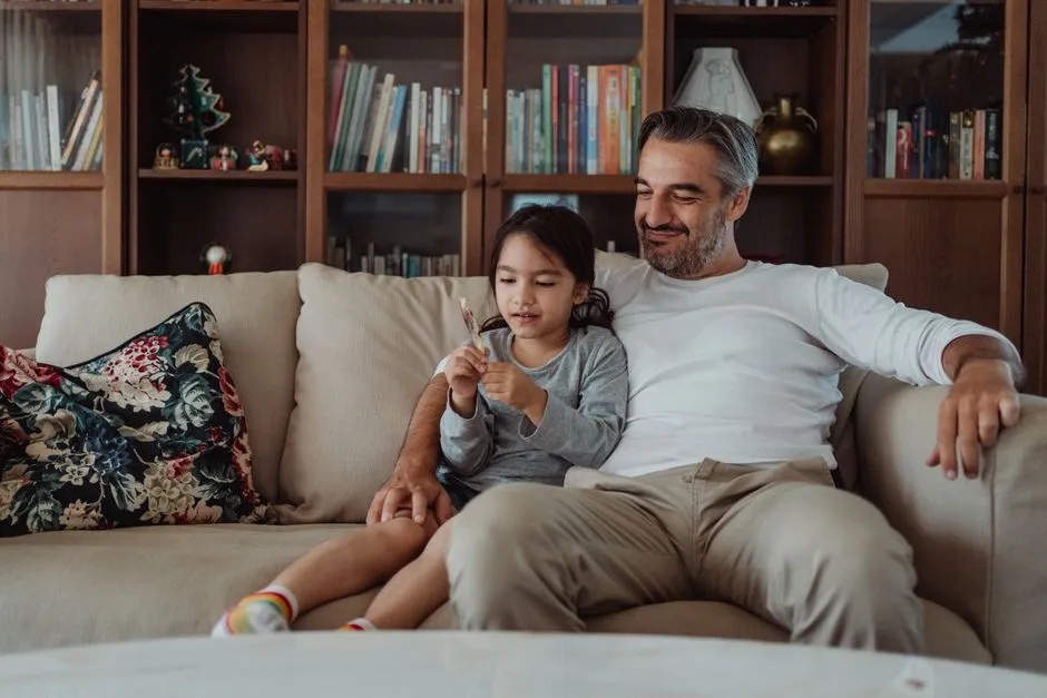 Parent and child sitting on a couch working through a reading round together on a tablet