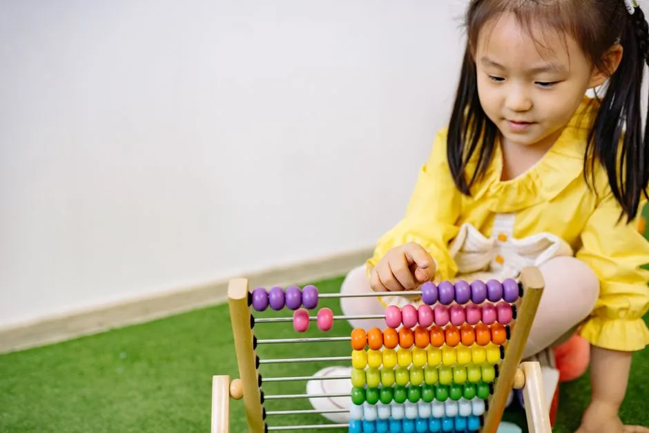 Year 1 student counting plastic counters beside a tablet game